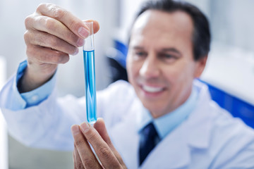 Chemical analysis. Selective focus of a test tube with blue liquid being used for scientific analysis in the lab