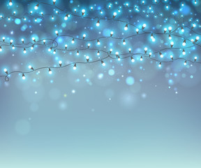 Glowing Christmas garlands on blue background with bokeh. Realistic luminous bulbs, magic lights for festive decoration. Fairy light effects for Christmas greeting cards, poster, flyer