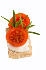 Sandwich with tomato, cheese and rosemary on a white background.