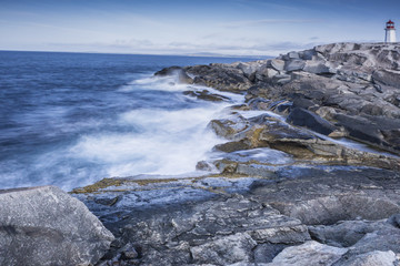 Peggy Cove Nova Scotia rocky shore with waves and lighthouse