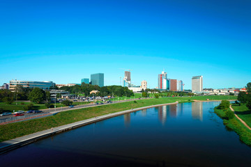 Cityscape with modern steel and glass skyscrapers reflected in river