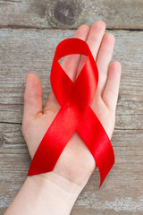 Aids red ribbon on woman's hand support for World aids day and national HIV/AIDS and aging awareness month concept
