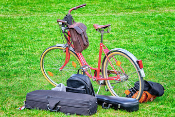 City bicycle and boxes for musical instruments on green lawn