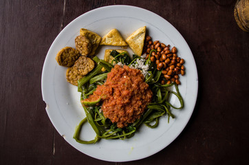 Indonesian dish kankung plecing (spicy water spinach dish) typical for Lombok island shot from top view, centered.