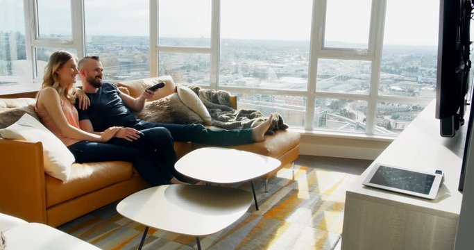 Couple watching television together in living room 