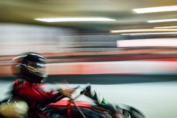 Cart blurred by high speed, a boy having fun - driving fast, racing, speeding.  © Szymon