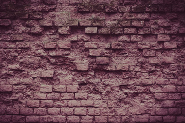 Ancient brick wall with traces of strong weathering. Old grunge wall in grunge style - tinted