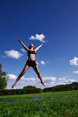 The girl in the Park, jumping up on the background of clear sky.