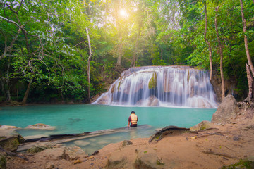 Man wearing a life jacket in a beautiful waterfall. Erawan waterfall kanchanaburi Thailand.