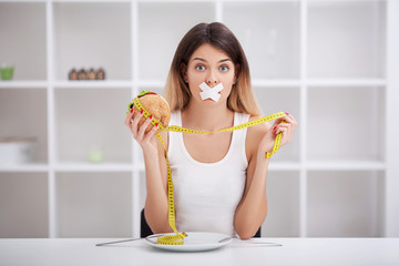 Diet. The concept of healthy and unhealthy nutrition. The model plus size makes a choice in favor...
