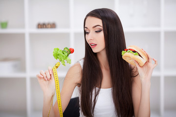 Diet. The concept of healthy and unhealthy nutrition. The model plus size makes a choice in favor...