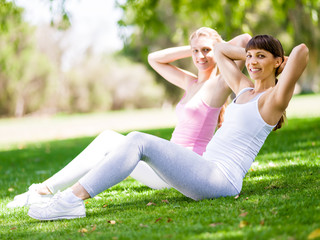 Naklejka na ściany i meble Young women exercising in the park