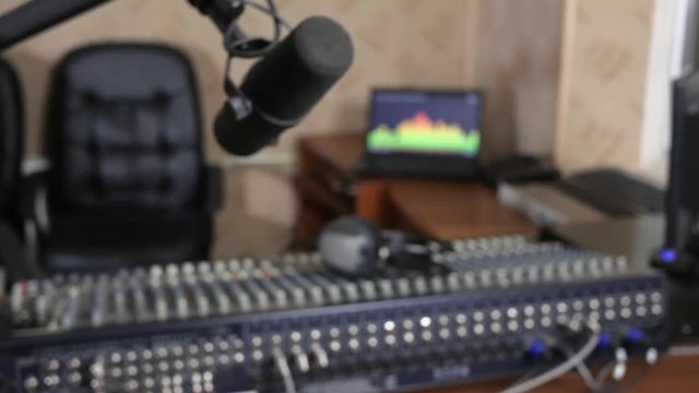 professional microphone in recording studio on background of audio console with headphones and notebook