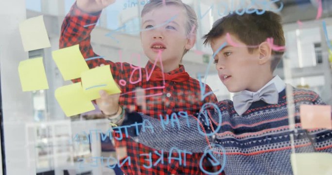 Kids as executives writing on sticking stick notes 