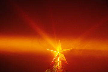 Christmas tree shiny star, orange background with smoke