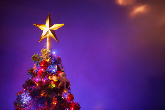 Christmas tree with festive star, purple background