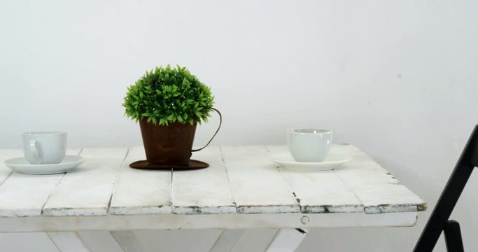 Cups and pot plant on wooden table 