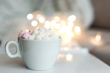 Cup of hot chocolate and marshmallow in the background of Christmas decorations.