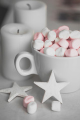 Cup of hot chocolate and marshmallow in the background of Christmas decorations.