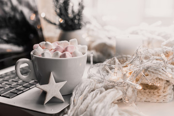 Cup of hot chocolate and marshmallow in the background of Christmas decorations.
