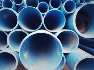 close-up view of stacked blue industrial pipes, showcasing their circular shapes and smooth...