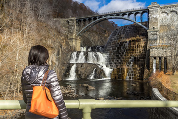 Girl watching Croton Dam waterfalls from nearby bridge at the Croton Gorge Park in New York © eileen10