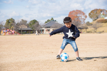 公園でサッカーをする子供 © tatsushi