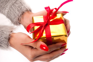 Woman hand holding golden box present with red bow