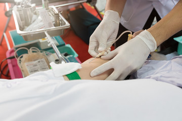 Nurse receiving blood from blood donor in hospital.
