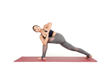 young asian woman practicing yoga in Virabhadrasana I or Warrior Twist yoga pose on the mat isolated on white background, exercise fitness, sport training and healthy lifestyle concept