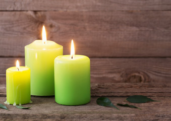 Fototapeta na wymiar green candles on dark wooden background