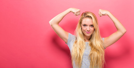 Obraz premium Powerful young woman in a success pose on a solid background