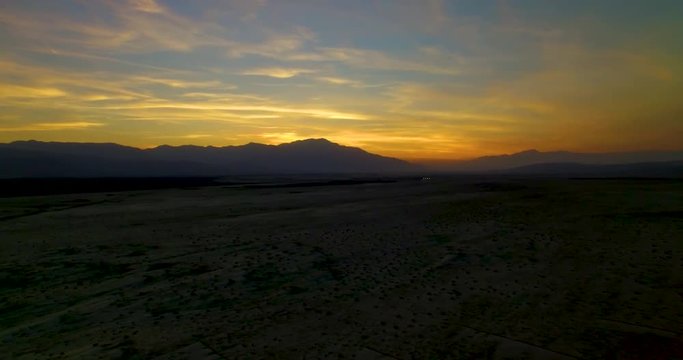 Panning aerial shot of mountains in Palm Desert and sunset on the horizon