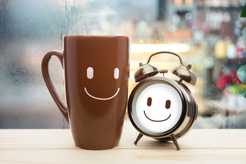 Steaming coffee cup and alarm clock on a rainy day window background, Good day