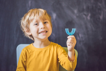 Three-year old boy shows myofunctional trainer. Helps equalize the growing teeth and correct bite,...