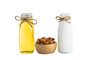 Bottle of almond milk and oil with Peeled almonds in wooden bowl isolated