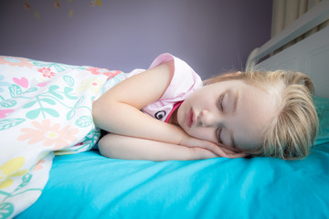 Obraz na płótnie Canvas little girl sleeping in her bed