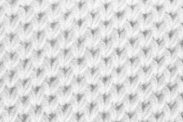 Texture of knitted fabric. The background is white in woolen thread.