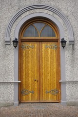Ornate wooden entry door with stone arch