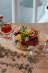 Clear bowl of sliced summer fruits on a dish towel