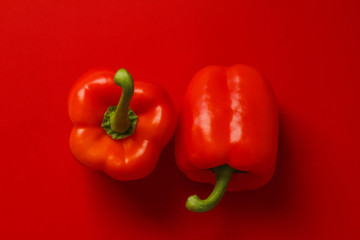 赤い背景の上に置かれた赤いパプリカ