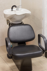  Black comfortable armchair with porcelain white hairdryer