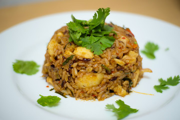 thai tom yum fried rice with mushroom and chicken in white plate