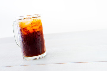 Glass of cola with ice on wood baord