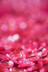 Many red little crystal hearts with bokeh background.