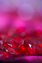 Many red little crystal hearts with bokeh background.