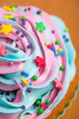 Closeup cupcake creamy multicolored top with colorful stars and sprinkles