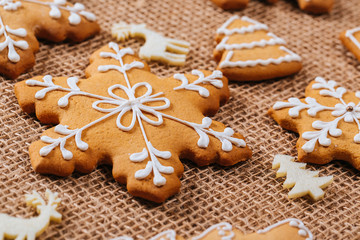 Christmas gingerbread cookies homemade and New Year decor on table with burlap tablecloth. Merry Christmas postcard.
