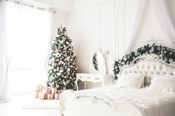 Christmas living room with a Christmas, gifts tree and bed. Beautiful New Year decorated classic home interior. Winter background