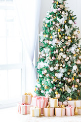 Christmas living room with a Christmas tree, gifts and a large window. Beautiful New Year decorated classic home interior